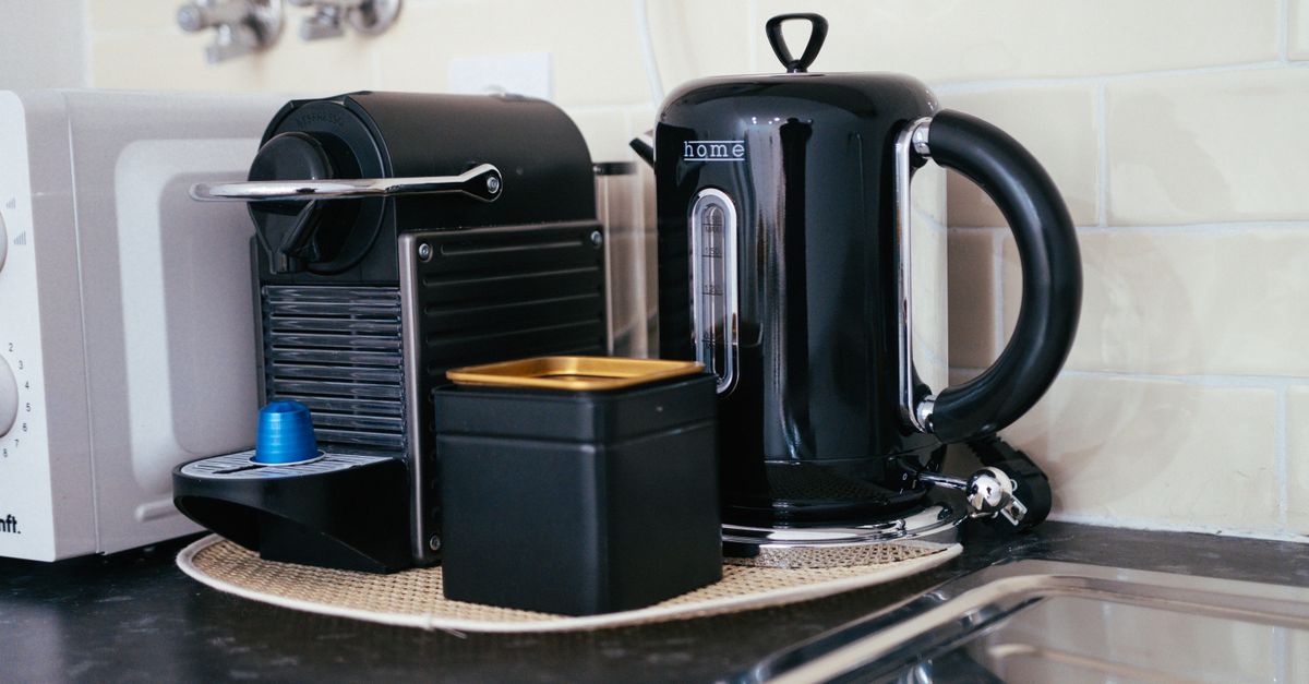 Sleek black coffee maker and kettle on a modern kitchen countertop, ideal for brewing.